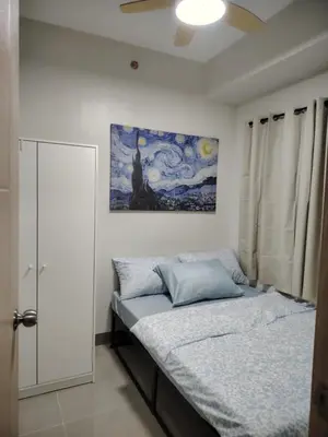 a bedroom with a bed and a painting on the wall at 2BR Mountain View Condo SMDC Charm Metro Manila in Manila