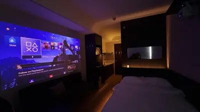 a bedroom with a bed and a large screen television at Highwind - Projector, Playstation 4, Pool in Silang