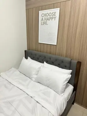 a bed with white pillows and a picture above it at The Hideout Condotel in Shore 2 Residences Tower 3 in Manila