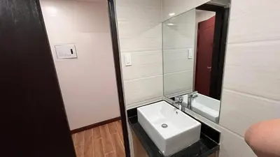 a bathroom with a sink and a mirror at Bayport West Naia Residences in Manila