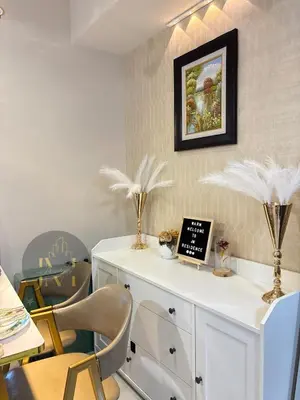 a room with chairs and a white cabinet with feathers on it at Luxurious & Elegant Unit in Parksuites BGC in Manila