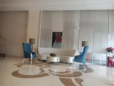 a lobby with a couch and chairs and a painting at 150 Newport Boulevard in Manila