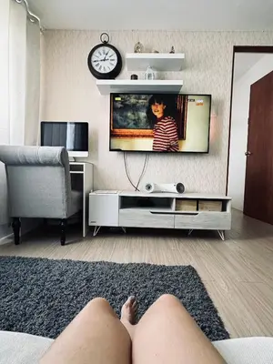 a person laying on the floor in a living room watching tv at The Hive Condo Staycation Condo at Taytay Rizal in Taytay