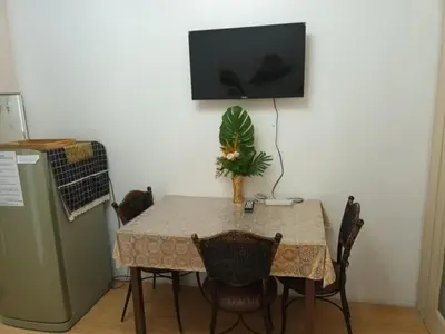 a table with chairs and a television on a wall at Sea Residences LJ Place in Manila