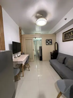 a living room with a couch and a table at Sea Residences Affordable Staycation Near MOA - by Rose in Manila