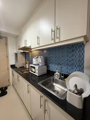 a kitchen with a sink and a microwave at Sea Residences Affordable Staycation Near MOA - by Rose in Manila