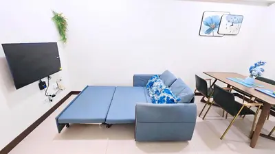 a living room with a table and a blue couch at 2 bed room in Fairlane Residences Pasig in Manila