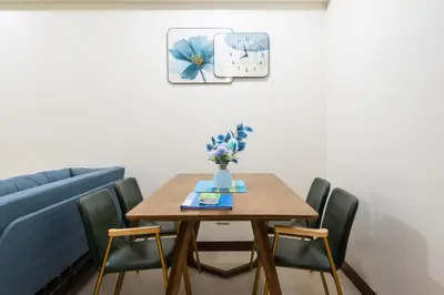 a dining room table with chairs and a blue couch at 2 bed room in Fairlane Residences Pasig in Manila