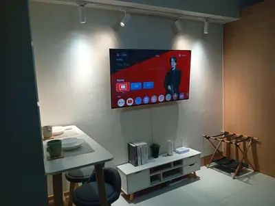 a television hanging on a wall in a room at Minimalist Big 1BR Pool View MOA Airport in Manila