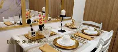 a dining room table with a white and gold table at Golden Shore Haven - Pasay in Manila