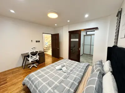 a bedroom with a bed and a desk and a chair at Halika Villa & Capitolo events place near BGC in Manila
