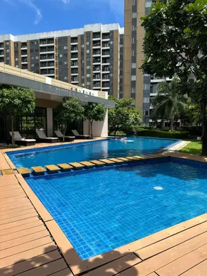 a large swimming pool in a city with tall buildings at Tower C 3rd Floor in Taytay