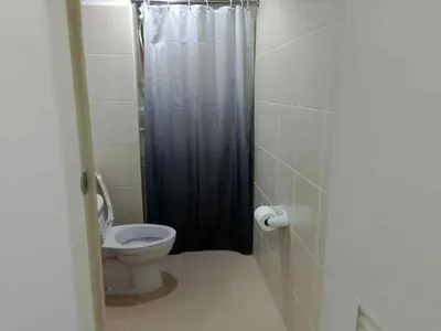 a bathroom with a toilet and a shower stall at Tabatina Grand Reviera Suites in Manila