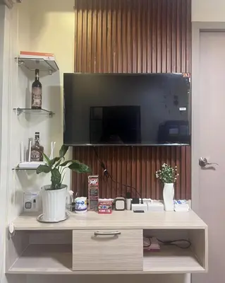 a entertainment center with a tv on a wall at Mazal Residence in Manila