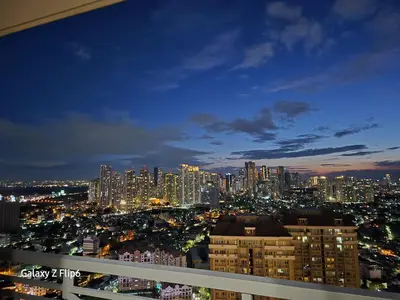 a view of a city skyline at night at Sweet Condo in Manila
