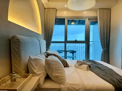 a bedroom with a bed with a view of a balcony at Panoramic Seaview 2BR near Airport Facing the Bay 6G in Manila