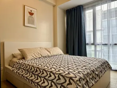 a bedroom with a bed and a large window at Naia T3 Condotel in Manila