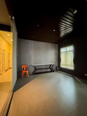 an empty room with a orange chair in the corner at Convertible Solo Budget Studio in Salcedo Village in Manila