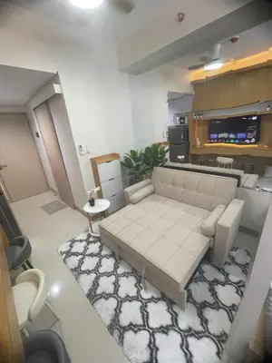 a living room with a couch and a kitchen at Field residences Building 9 in Manila