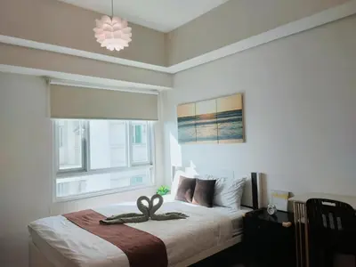 a bedroom with a bed with a ribbon on it at The Catalina at The Beacon Makati in Manila