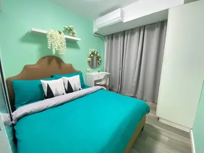 a blue bedroom with a large bed with blue walls at Leisure escape Azure in Manila