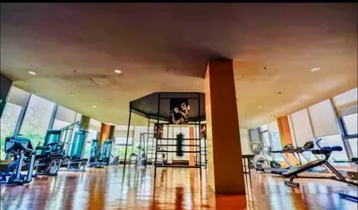 a gym with cardio equipment in a large room with windows at The Radiance Manila bay 2BR in Manila