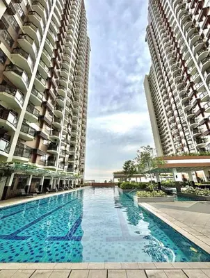 two tall buildings with a swimming pool between them at The Radiance Manila bay 2BR in Manila