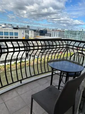 a table and chair on a balcony with a view of a city at Solemare Parksuites with balcony in Manila