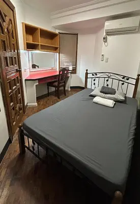 a bedroom with a bed and a desk in a room at Manila Gateway Hostel in Manila