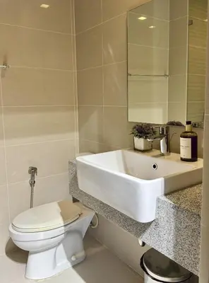 a bathroom with a white sink and a toilet at Stylish 1BR with balcony inside BGC at Uptown Parksuites - 20d in Manila