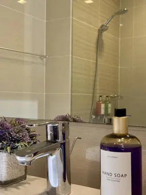 a bottle of hand soap sitting on a bathroom sink at Stylish 1BR with balcony inside BGC at Uptown Parksuites - 20d in Manila