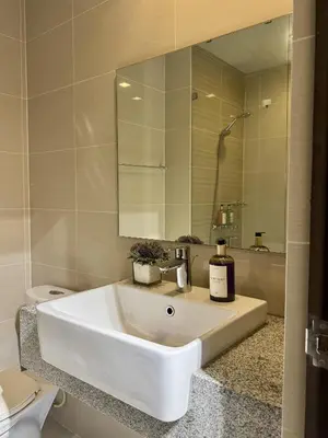 a bathroom with a white sink and a mirror at Stylish 1BR with balcony inside BGC at Uptown Parksuites - 20d in Manila