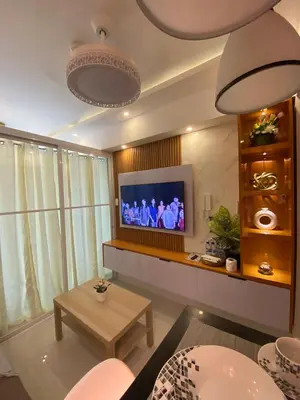a living room with a television and a table at HomeSuiteHome, Shore 3 Residences Moa Complex, Pasay City in Manila