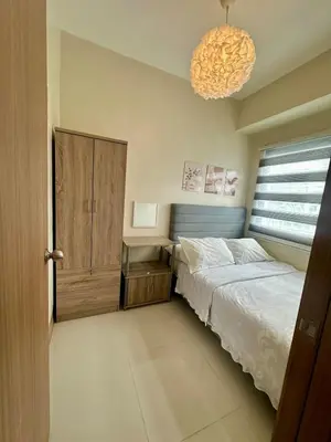 a bedroom with a bed and a desk and a chandelier at Mall of Asia Staycation with fast wifi and google tv in Manila