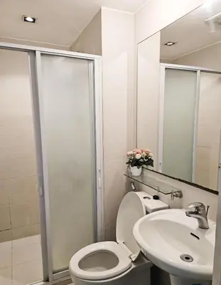 a bathroom with a toilet and a sink and a shower at NEMM Staycation in Manila