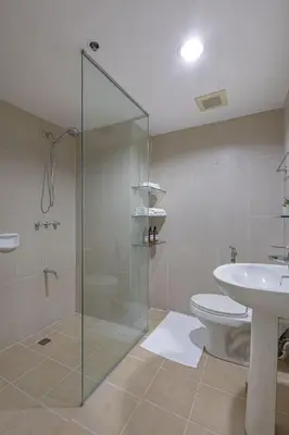 a bathroom with a shower and a toilet and a sink at 2 BR Golf View Loft Timeless Charm in Avant BGC in Manila
