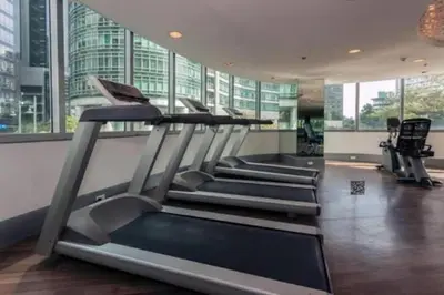 a gym with several tread machines in a building at 2 BR Golf View Loft Timeless Charm in Avant BGC in Manila