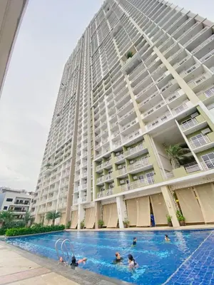 a large building with people in a swimming pool at Staycation by Darvy in Manila