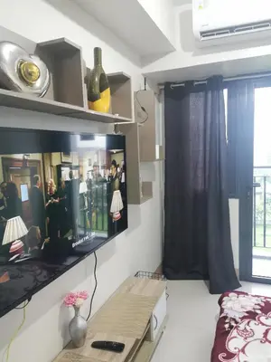 a room with a bed and a window and a table at Aldo mall of Asia condotel in Manila