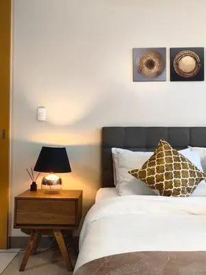 a bedroom with a bed and a nightstand with a lamp at Uptown BGC Spacious 1BR Unit by Terravista - Prague Suite in Manila