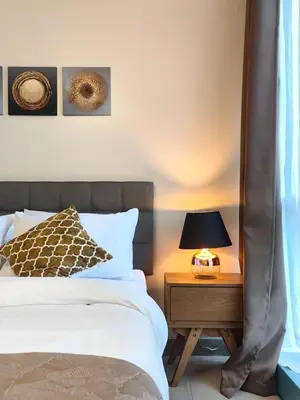 a bedroom with a bed and a table with a lamp at Uptown BGC Spacious 1BR Unit by Terravista - Prague Suite in Manila