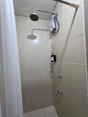 a bathroom with a shower with a shower curtain at Pioneerwoodlands Mandaluyong Studio Unit in Manila