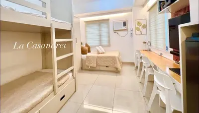a dorm room with bunk beds and a table at La Casandrei in Dasmariñas
