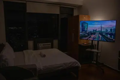 a bedroom with a bed and a flat screen tv at D-Studio,Best Sunset Pool,Luxury,Hotel Style in Manila