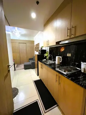 a kitchen with a sink and a counter top at Chateau Staycation in Manila