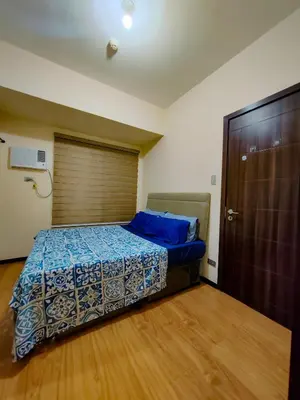 a bedroom with a bed with blue sheets and a door at LeMoon's Chill with beautiful view-1 Bedroom in Manila