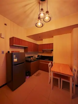 a kitchen with a wooden table and a black refrigerator at LeMoon's Chill with beautiful view-1 Bedroom in Manila