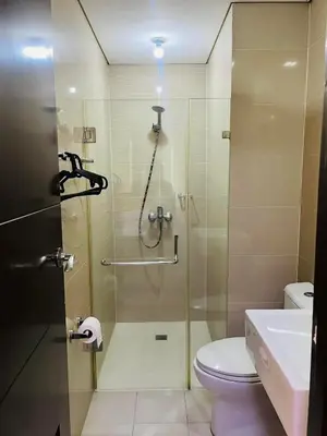 a bathroom with a shower with a toilet and a sink at Walking Distance Condo Across Naia T3 Airport in Manila