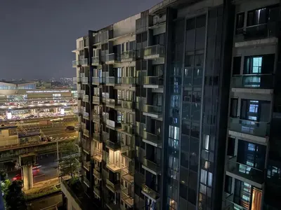 a tall building at night with a city at Kyedenz Unit -Two Palm Tree Villas Newport Naia T3 in Manila