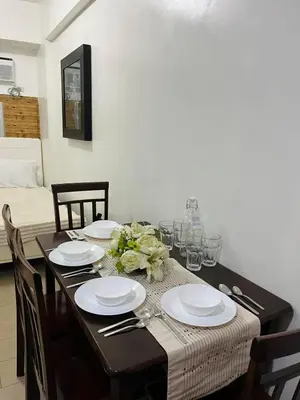 a dining room table with plates and silverware on it at Kyedenz Unit -Two Palm Tree Villas Newport Naia T3 in Manila